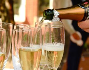 A person pouring champagne into glasses