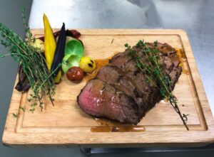 A large piece of meat on top of a cutting board.